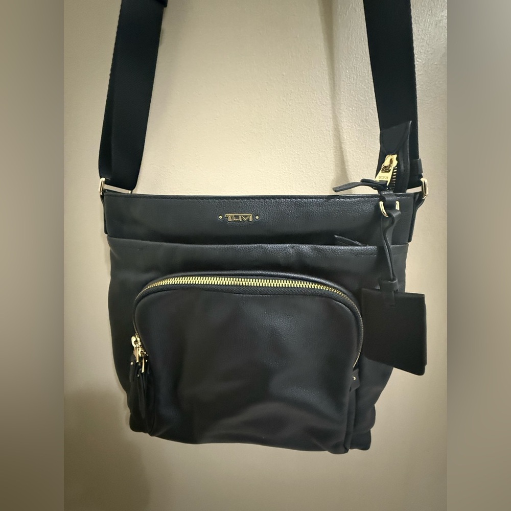 TUMI crossbody leather Black with gold hardware.